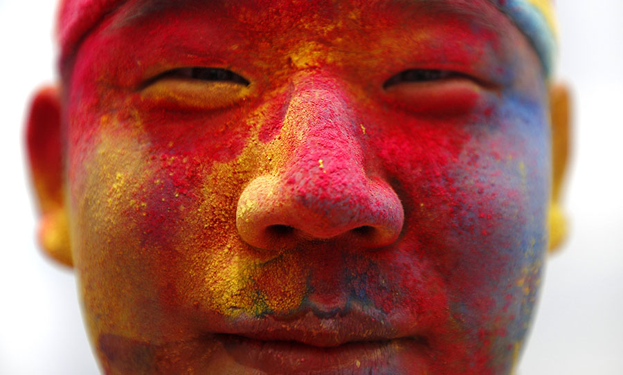 Competitor covered in coloured powder poses for a picture during the Color Run in Shanghai