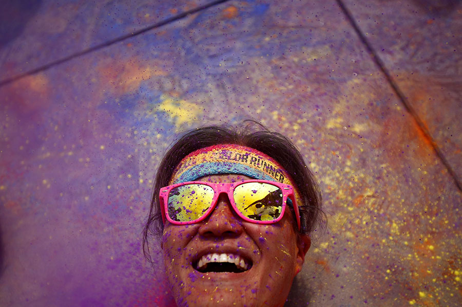 Competitor rolls in colored powder as she participates in the Color Run in Shanghai