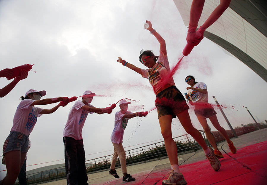 Competitor has coloured powder sprayed at her during the Color Run in Shanghai